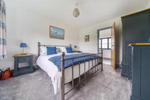 a bedroom with a bed with blue sheets and a mirror at EASTFIELD HOUSE in Whissonsett