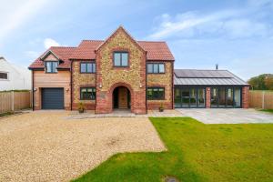 a large brick house with a garage at EASTFIELD HOUSE in Whissonsett