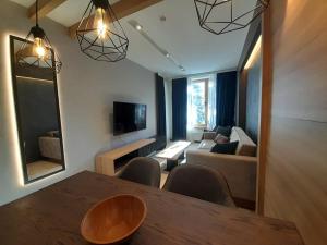 a living room with a table and a couch at Woodside RENT Kopaonik in Kopaonik