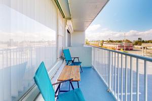 a balcony with two chairs and a wooden table at Daytona Dreamin' Unit 320 in Daytona Beach