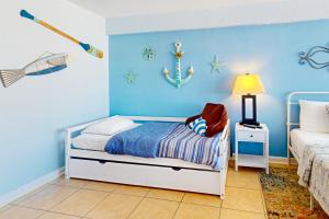 a bedroom with a bed and a blue wall at Daytona Dreamin' Unit 320 in Daytona Beach