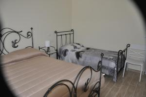 a bedroom with two twin beds and a chair at La Vecchia Lanterna in Montecorvino Rovella