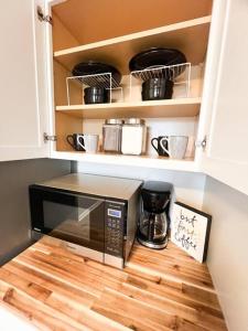 a microwave on a wooden floor in a kitchen at The Gateway: Entire Apartment 7 mins from airport in Cleveland