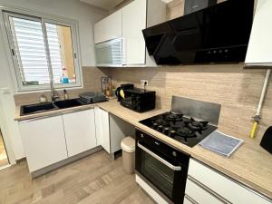 eine Küche mit Herd und Arbeitsplatte in der Unterkunft Abilia Suite - À Proximité de l'Aéroport - Confort et Élégance in La Soukra