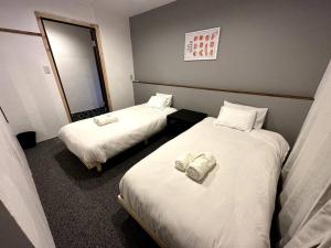 a hotel room with two beds and a mirror at AOBA Hakuba self-contained home in Hakuba