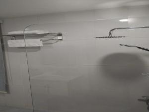 - Baño con puerta de ducha de cristal y toallas en غيمة للشقق الفندقية en Yeda