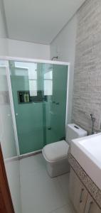 a bathroom with a toilet and a glass shower at Casa Vista Pontal in Ilhéus