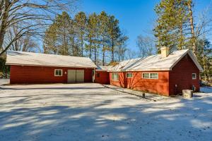 ein rotes Haus mit Garage im Schnee in der Unterkunft Lakefront Townsend Cabin with Fire Pit and Dock! 