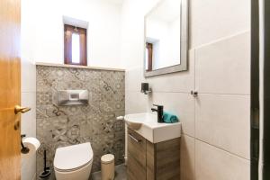 Łazienka z białą toaletą i umywalką w obiekcie Hotel Sonnenhang w mieście Kempten