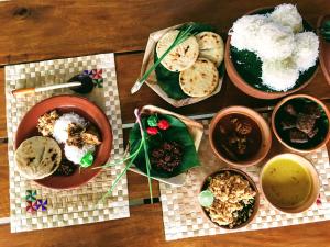 a wooden table with bowls of food on it at The Vintage Villa - Knuckles in Rangala