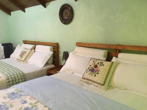 ein Schlafzimmer mit 2 Betten und einer Uhr an der Wand in der Unterkunft The Vintage Villa - Knuckles in Rangala