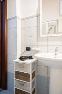 a white bathroom with a sink and a white sink at B&B La Rosa Lampedusa in Lampedusa
