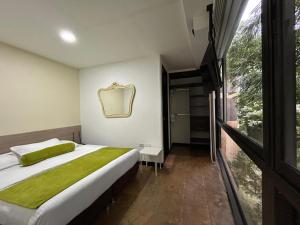 a bedroom with a bed and a large window at Suite Presidencial en hotel próximo al aeropuerto in Rionegro