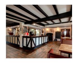 a restaurant with a bar in the middle of a room at Self Check-In Rooms at The Three Horseshoes Inn in Bromyard