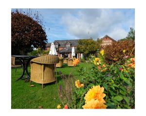 a garden with a table and chairs and flowers at Self Check-In Rooms at The Three Horseshoes Inn in Bromyard