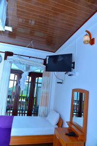 a bedroom with a bed with a tv and a mirror at La Montagna in Ella