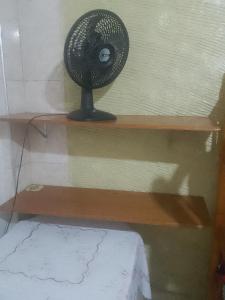a small fan sitting on a wooden shelf at Hostel Espaço Barra Funda in Sao Paulo