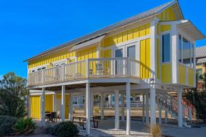 a yellow house with a porch and a deck at Sunshine Haven in Carrabelle