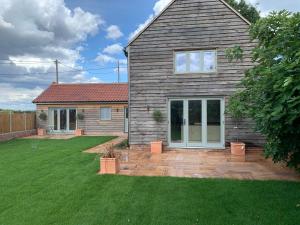 a house with a garden and a yard with grass at Lodge Cottage in Harwich