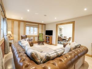 a large leather couch in a living room at Lodge Cottage in Harwich