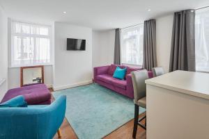 a living room with a purple couch and a table at Host & Stay - The Globe, Apartment 3 in Guisborough