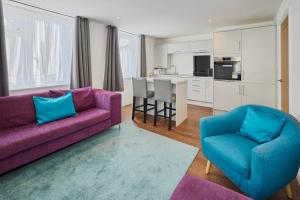 uma sala de estar com um sofá roxo e duas cadeiras em Host & Stay - The Globe, Apartment 3 em Guisborough