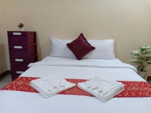 a white bed with two folded towels on it at Bang Yan Rimlay in Ko Yao Noi