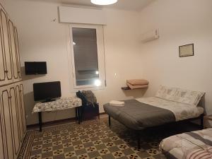 een kleine slaapkamer met een bed en een televisie bij B&B Matteotti 23 in Bologna