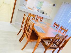 a wooden dining room table and chairs in a kitchen at EThembeni Guesthouse in Gqeberha
