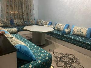 een woonkamer met een bank en een tafel bij Appartement Ouargaga in Meknès