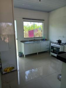 una cocina con fregadero y una ventana. en casa axé luz no paraíso, en Alto Paraíso de Goiás