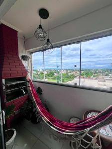 a room with a hammock in front of a window at Apartamento decorado no Jardim Lancaster in Foz do Iguaçu