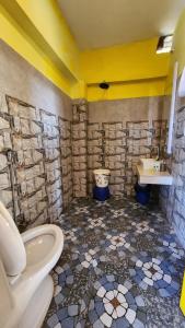 La salle de bains est pourvue de toilettes et d'un lavabo. dans l'établissement Neelkanth Retreat Mukteshwar, à Mukteswar