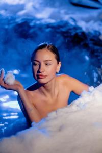 a woman sitting in the water with a cloud at Nikol Guest House in Bukovel