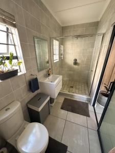 a bathroom with a toilet and a sink and a shower at Sunny Shores Hideaway in Cape Town