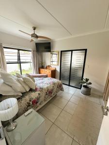 a bedroom with a bed and a ceiling fan at Sunny Shores Hideaway in Cape Town