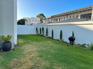 a backyard with a grill on the side of a building at Sunny Shores Hideaway in Cape Town