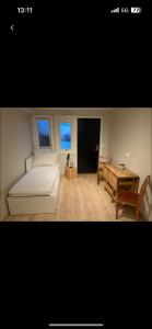 een woonkamer met een witte bank en een tafel bij Liten koselig hybelleilighet for 1 til 2 personer - sentral beliggenhet og gunstig pris in Tromsø