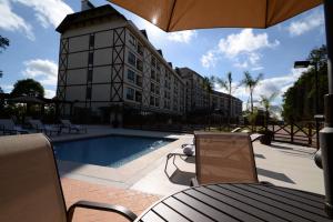 un hotel con piscina y un edificio en Vista Azul Apart Hotel - Vista Pedra Azul, en Domingos Martins