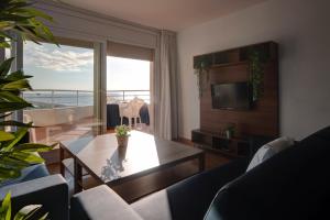 サンタ・スサナにあるApartamentos Bon Repósのテーブルがあり海が見えるリビングルーム