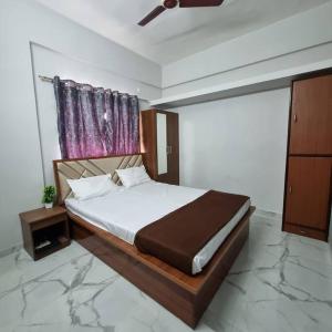 um quarto com uma cama grande e uma janela em Katke's HomeStay. em Sholapur