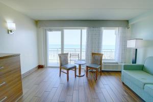 - un salon avec un canapé, une table et des chaises dans l'établissement Marjac Suites Virginia Beach Oceanfront, à Virginia Beach