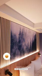 a bedroom with a large painting of a forest at Hotel Lamm in Baiersbronn
