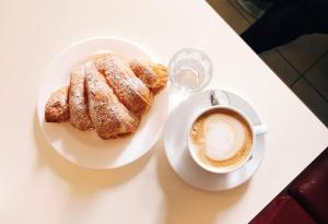 a plate of pastry and a cup of coffee on a table at Mikasa Balduina Roma in Rome