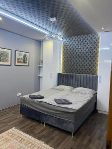 Hotello Apartmanház és Panzió في زالاجيرسيج: غرفة نوم بسرير كبير بسقف ازرق
