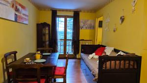 ein Wohnzimmer mit einem Sofa und einem Tisch in der Unterkunft Hostdomus - Casa Borgata in Borgata Sestriere