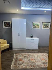 una stanza con un armadio bianco e un tappeto di Hotello Apartmanház és Panzió a Zalaegerszeg
