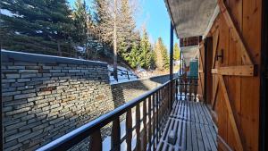 a building with a fence and a brick wall at Hostdomus - Casa Borgata in Borgata Sestriere