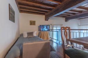 Schlafzimmer mit einem Bett und einem Esstisch in der Unterkunft Exclusive Duplex Apartment in the City Center x9! in Ferrara