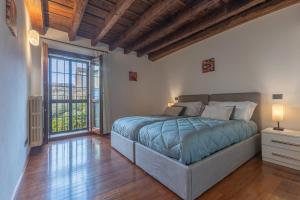 ein Schlafzimmer mit einem Bett und einem großen Fenster in der Unterkunft Exclusive Duplex Apartment in the City Center x9! in Ferrara